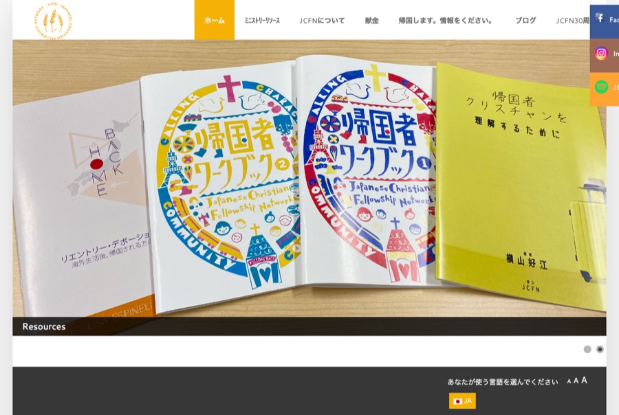 The live Joomla jcfn.org home page in Japanese: a large photo carousel of printed workbooks fills the screen beneath a crowded navigation bar, with social media buttons overlapping the content.
