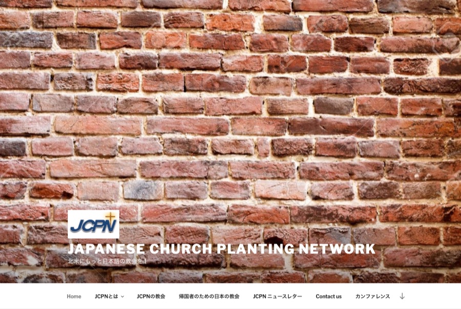 The previous jcpnetwork.com home page: a stock WordPress theme where a full-width photograph of a brick wall fills the screen above the site title.